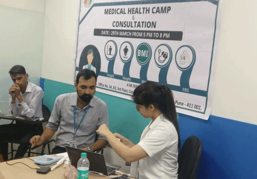 AM InfoWeb medical health camp showing doctors and volunteers providing basic health check-ups for community members.
