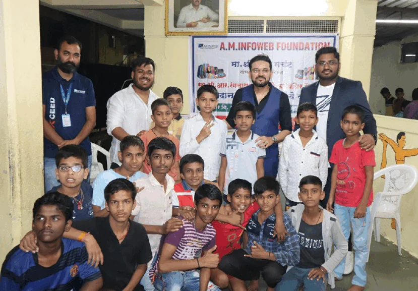 AM InfoWeb school charity initiative showing team members interacting with children during an education support activity.